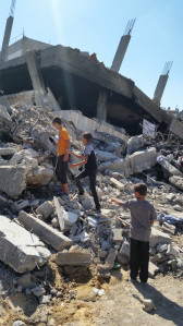 Palestinian children climb in rubble.