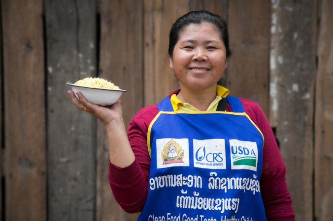 Hongkham Phengsaphone, age 36, holds a bowl of lentils at the Nahangnoy Primary School, where CRS’ LEAPS program provides students with a free school lunch. Photo by Jim Stipe/Catholic Relief Services
