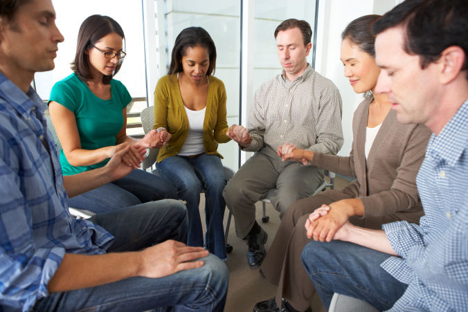 Bible Group Praying Together Holding Hands With Eyes Closed
