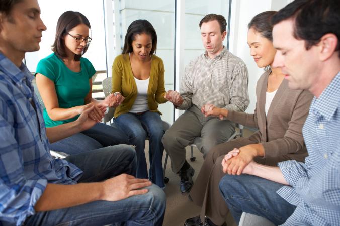 Bible Group Praying Together Holding Hands With Eyes Closed
